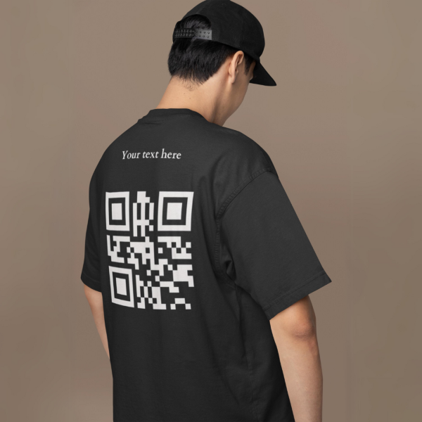 A person from the back, wearing a black cap and t-shirt with "Your text here" and a QR code in white on the upper back.